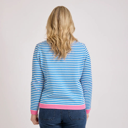 Lady wearing a blue and white striped sweater with pink trim on a plain background